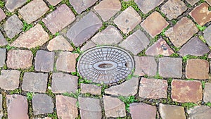 Cobblestone road to hatch underground utilities. Hatches sewer