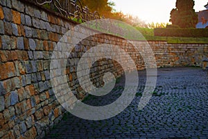 cobblestone street courtyard of medieval palace brick wall and paved floor Wester Ukrainian city landmark view in evening sun
