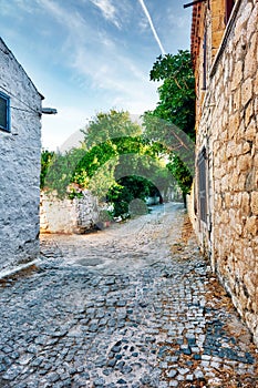 Cobblestone street and historical stone houses in Alacati, Turkey