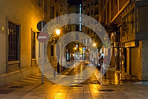Cobblestone street lit with street lamps at night in Malaga, Spa