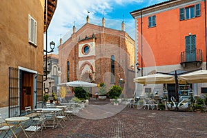 Cobblestone street and San Domenico church in Alba, Italy.