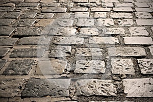 Cobblestone street surface closeup dark backlit