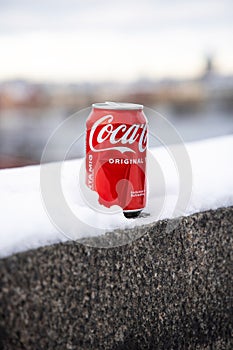 Coca cola can left in the city on the snow.