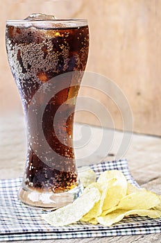 Coca cola in glass with potato chips photo