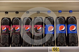 Coca Cola and Pepsicola on the shelves in the supermarket