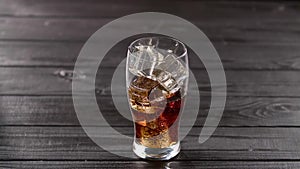 Coca cola pouring into glass with ice
