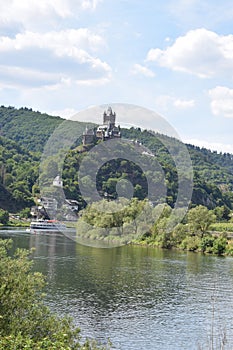 Cochem, Germany - 07 13 2020: Reichsburg with a cruise ship passing on the Mosel