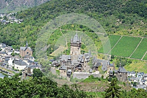 Cochem, Germany - 07 13 2020: Reichsburg in summer with green vineyards behind