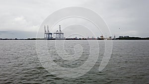 Cochin Port view from backwater. Logistics and transportation activities. Large container cargo ship moving in the ocean near