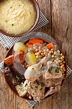 Cocido or cozido is a traditional stew eaten as a main dish in Spain, Portugal, Brazil close-up on a plate. Vertical top view