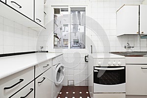 Kitchen with furniture and drawers in white tones with details and edges in black with a metal photo