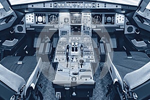 Cockpit of airliner simulator. Switches and dials visible in the background