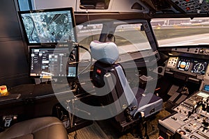 Cockpit of airliner simulator. Switches and dials visible in the background