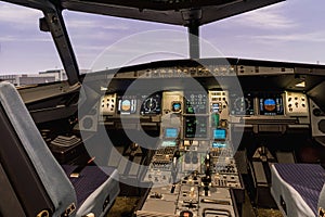 Cockpit of airliner simulator. Switches and dials visible in the background