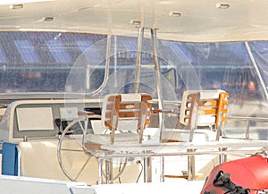 Cockpit of the boat with metal handle and wooden chairs