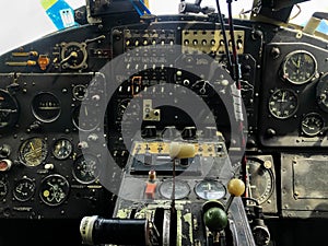 The cockpit control panel of the old plane close up. Detail of an old airplane cockpit with various indicators, buttons