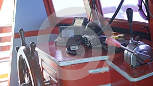 Cockpit of fishing boat in Asia, Thailand. Empty cockpit with wheel and navigation equipment on fishing vessel on sunny