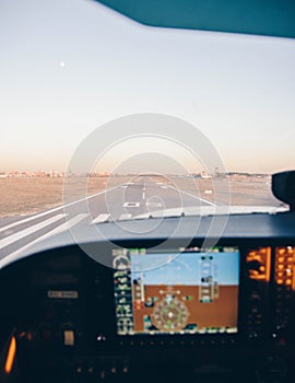 Cockpit of a small plane landing on the airport runway at sunset