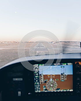 Cockpit of a small plane landing on the airport runway at sunset