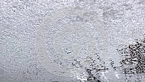 Cockpit view. Ice melts on the windshield of the car. 4K resolution