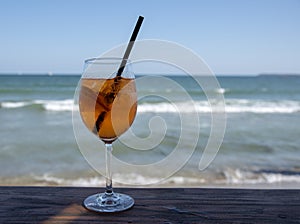 Cocktail aperol-spritz over the sea background.