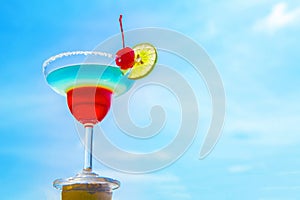 Cocktail on beach, blue sea and sky background