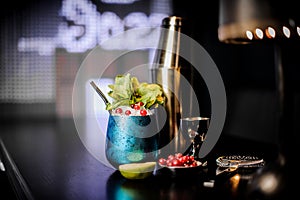 Cocktail in the blue steel cup with mint and red berries