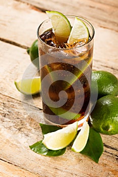 Cocktail with cola ice cubes and lime