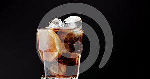 Cocktail with cola and limes slices isolated on black