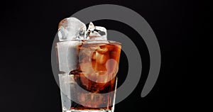 Cocktail with cola and limes slices isolated on black