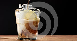 Cocktail with cola and limes slices isolated on black