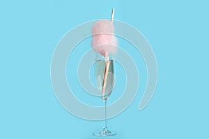 Cocktail with cotton candy in glass on blue background