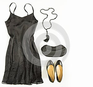 Cocktail dress outfit, night out look on white background. Little black dress, evening bag, black shoes, black tassel necklace. Fl