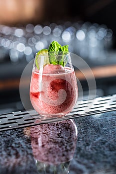 Cocktail drink frozen strawberry daiquiri at barcounter in night club or restaurant