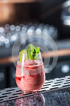 Cocktail drink frozen strawberry daiquiri at barcounter in night club or restaurant