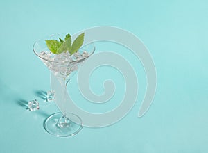 Cocktail drink ice mint leaves martini glass turquoise blue background