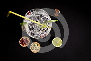 Cocktail of gin and tonic on a black background with his ingreedientes
