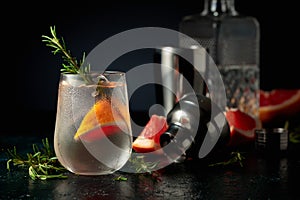 Cocktail gin tonic with ice, grapefruit, and rosemary