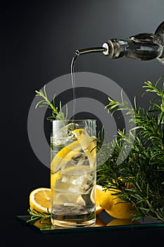 Cocktail gin tonic with ice, lemon, and rosemary