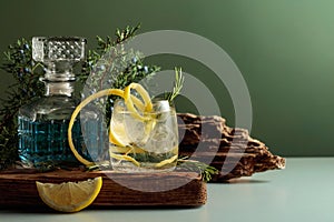 Cocktail gin-tonic with ice, lemon, and rosemary in a frozen glass