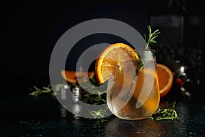 Cocktail gin tonic with ice, orange, and rosemary