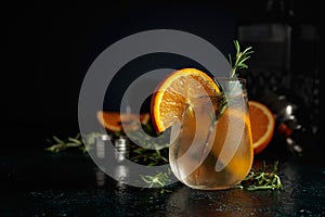 Cocktail gin tonic with ice, orange, and rosemary photo