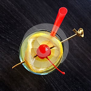 Cocktail glass decorated with lemon and cherry