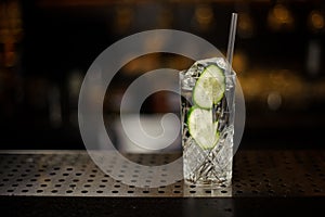 Cocktail glass filled with fresh alcoholic drink with cucumber slices and gin