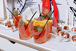 Cocktail glass with orange slices and mint leaves with black cocktail straws