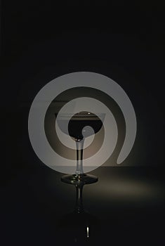 Cocktail Glass Shadow Ã¢â¬' Dramatic Low-Angle Light Casting Sharp Shadow on Dark Surface