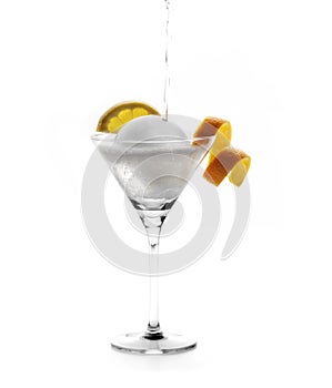 Cocktail glass with slices of lemon and orange with a large round ice photo