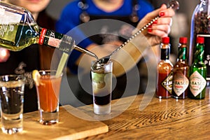 Cocktail in a glass with Tobasco and alcohol. Interior of the bar.