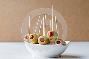Cocktail Green Olives Stuffed with Red Paprika Pepper Served with Toothpick.