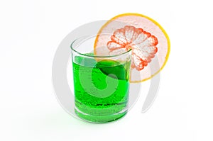 Cocktail of green soda with grapefruit on the edge of a transparent glass